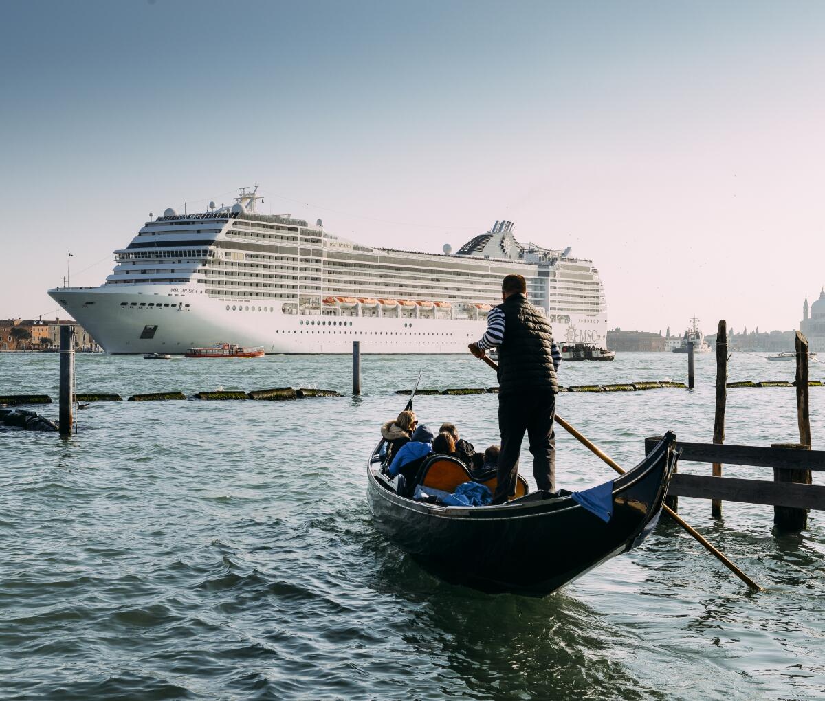 A gondolier in Venice, Italy, looks at a large cruise ship in Giudecca Canal.