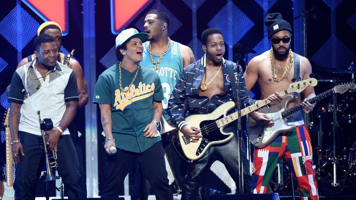 Bruno Mars, in an Oakland Athletics jersey, with members of his band.