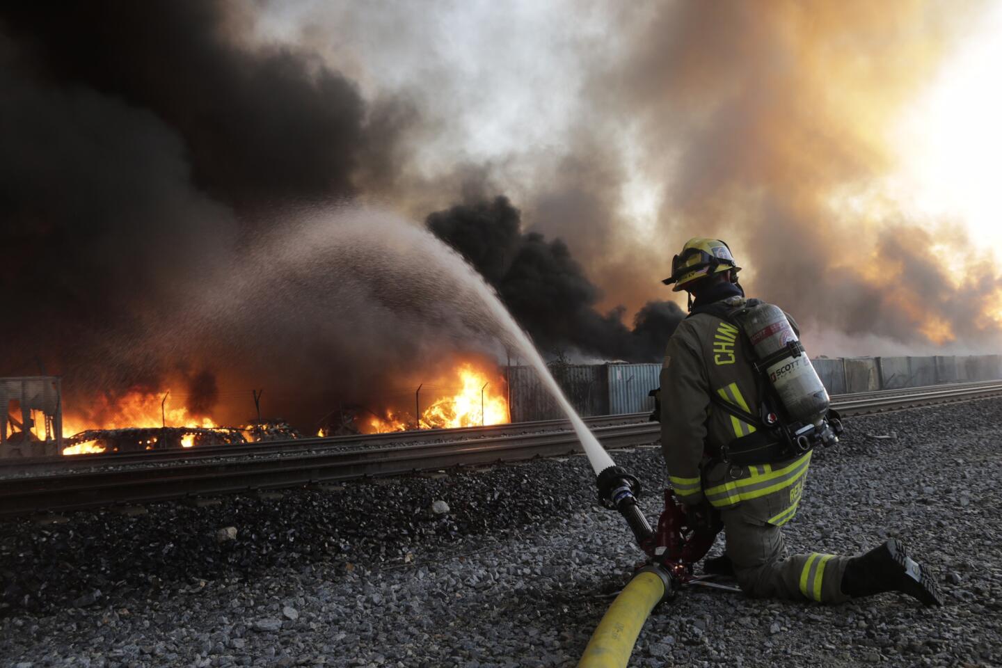 Firefighters on Friday battle a fast-moving fire at an Ontario recycling center that has sent huge flames into the air and plumes of smoke that could be seen for miles.