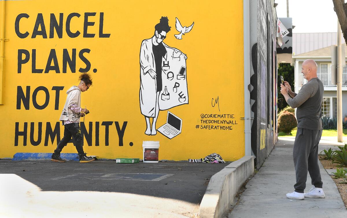 A mural in West Hollywood reads: "Cancel plans. Not humanity."
