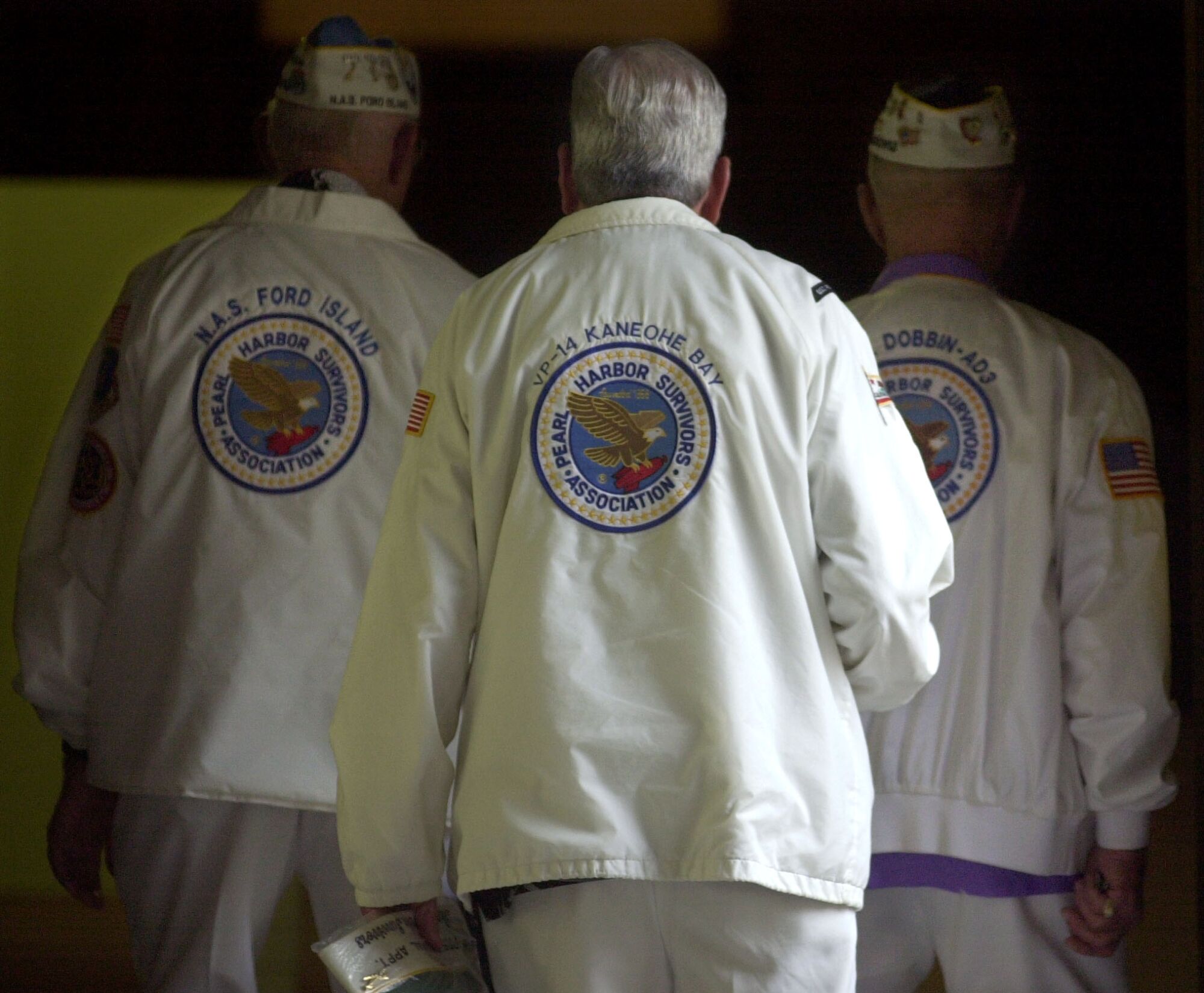 Members of The Pearl Harbor Survivors Association walk down a hall