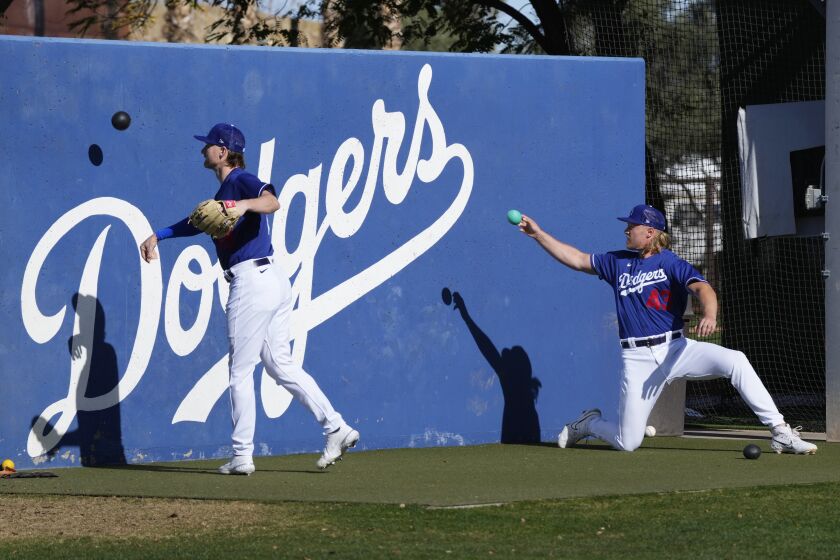 Los Angeles Dodgers pitchers Shelby Miller and Noah Syndergaard (43) warm up during the first day of spring training baseball workouts for Dodgers pitchers and catchers in Phoenix, Thursday, Feb. 16, 2023. (AP Photo/Ross D. Franklin)