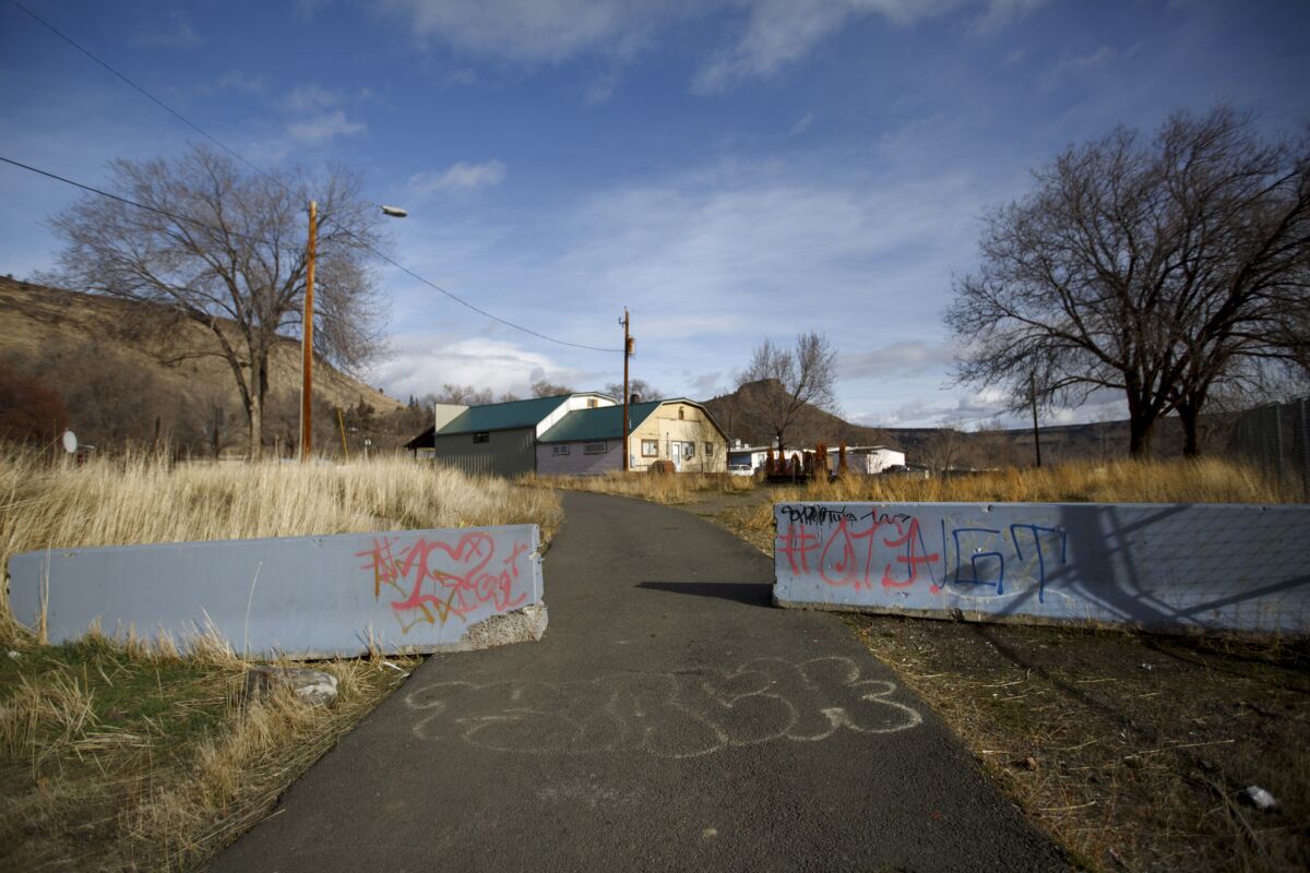 Abandoned homes sit behind concrete barriers on a road in Warm Springs.