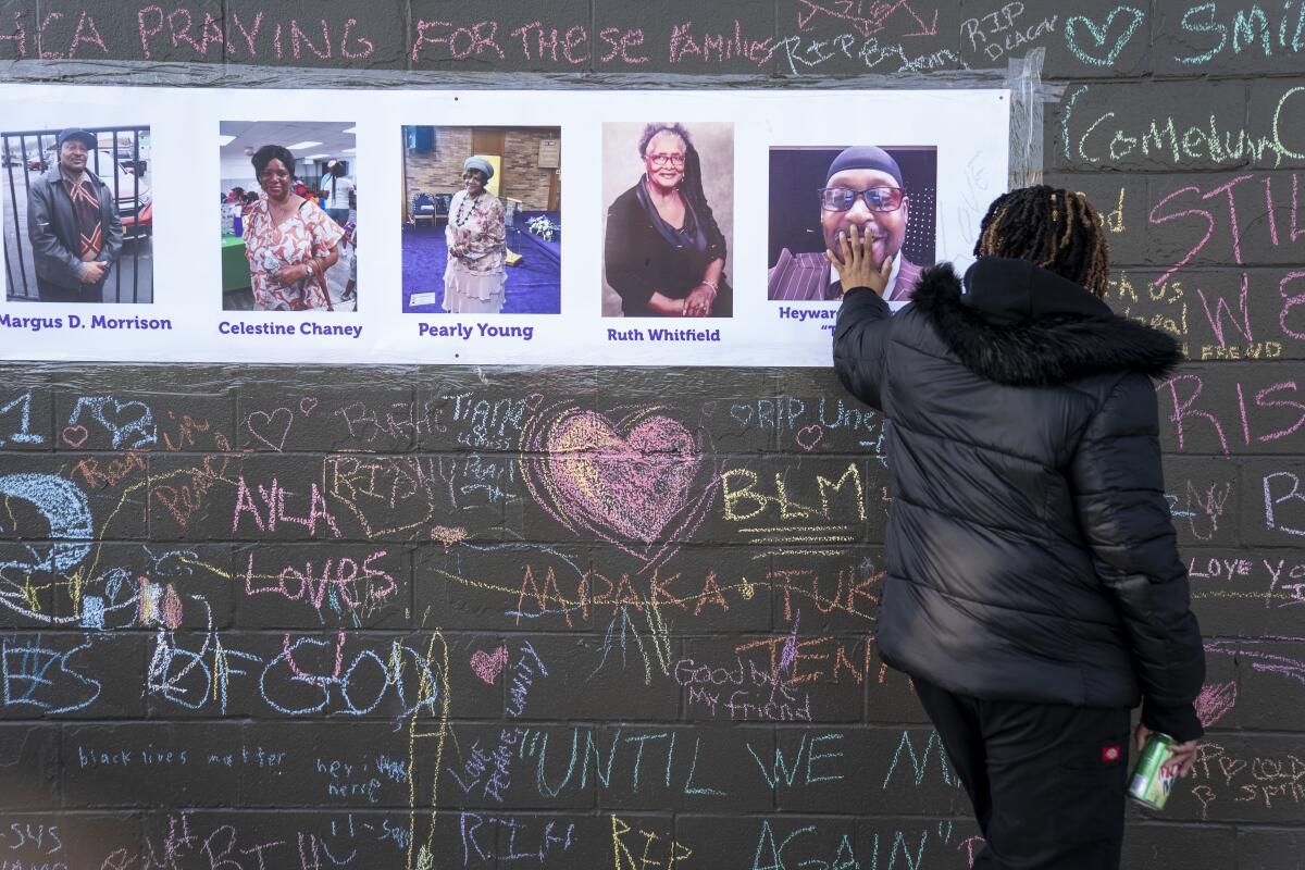 A woman touching a photo on a memorial for shooting victims
