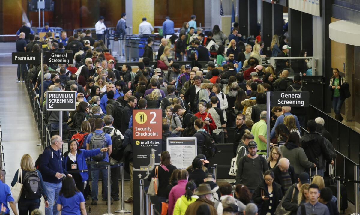 Travelers wait in line for security screening at Seattle-Tacoma International Airport in March.