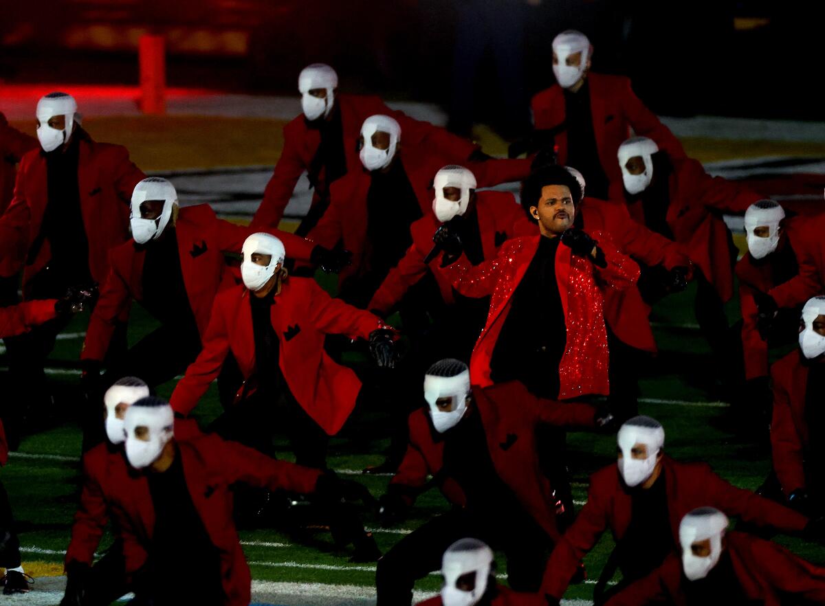 The Weeknd is surrounded by masked performers during the Super Bowl LV halftime show Sunday