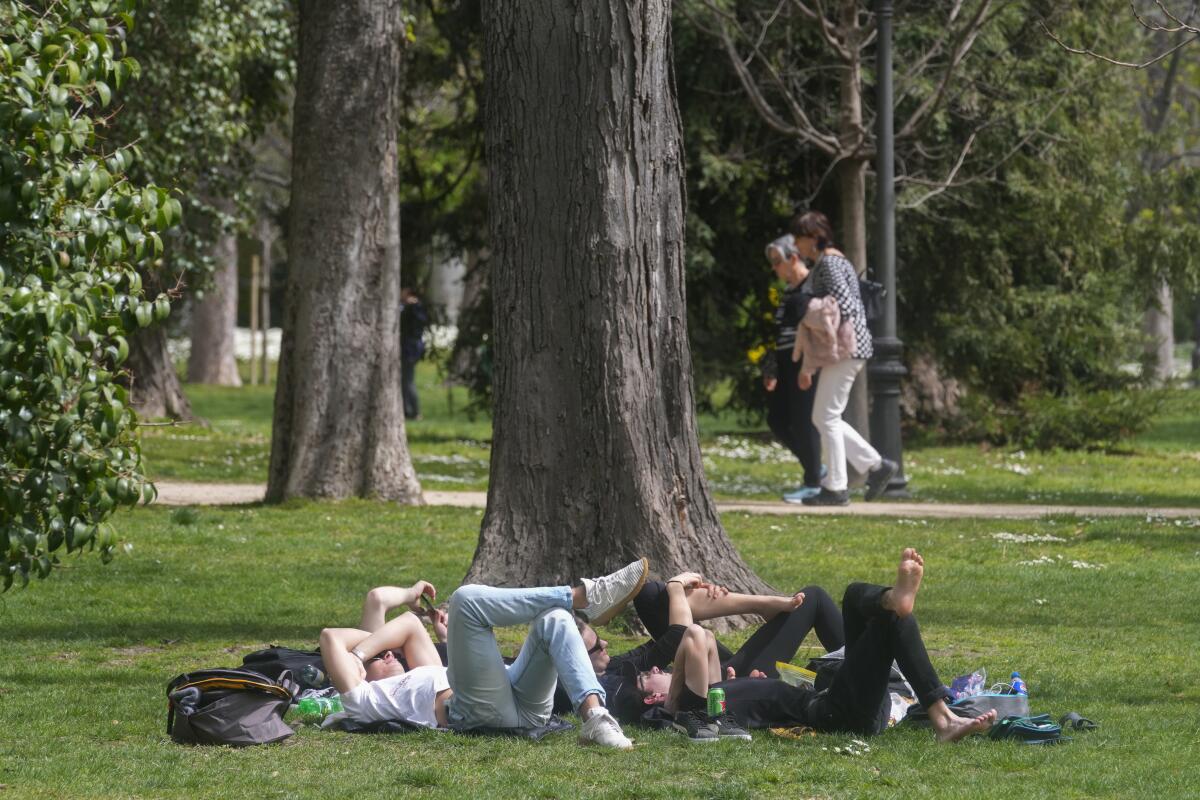 ARCHIVO - Varias personas descansan en el parque del Retiro el miércoles 20 de marzo de 2024