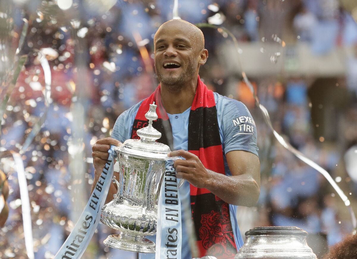 FILE - In this file photo dated Saturday, May 18, 2019, Manchester City's team captain Vincent Kompany lifts the trophy after winning the English FA Cup Final soccer match between Manchester City and Watford at Wembley stadium in London. The 34-year old Vincent Kompany who left Manchester City in 2019, has ended his 17-year playing career to focus on being head coach of Belgian team Anderlecht, it is announced Monday Aug. 17, 2020.(AP Photo/Tim Ireland, FILE)