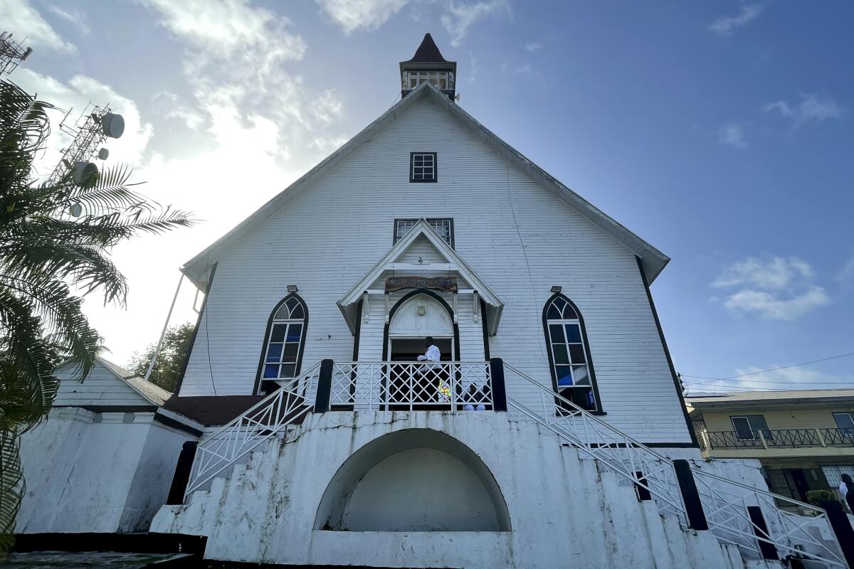 A man stands at the entrance of First Baptist Church on Colombia's San Andres Island on Sunday, Aug. 21, 2022. The church is a symbol of emancipation and a source of pride for the Raizals, the English-speaking, mostly Protestant inhabitants of San Andres and smaller islands that form an archipelago in the western Caribbean. (AP Photo/Luis Andres Henao)