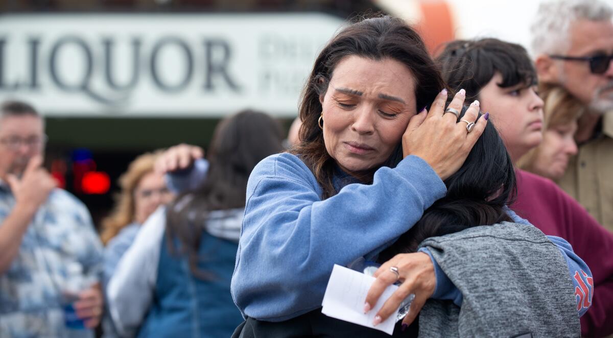Glori Smiley embraces loved ones mourning the death of her daughter, Rosenda Elizabeth Smiley.
