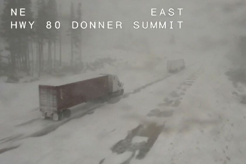 In this image taken from video from a Caltrans remote video traffic camera, a pair of trucks make their way through the snowy conditions along Interstate 80 at Donner Summit, Calif., Thursday, Dec. 1, 2022. The National Weather Service has issued a winter storm warning stretching into Friday for much of the Sierra, including Lake Tahoe where up to 2 feet (61 centimeters) of snow and winds gusting to near 100 mph (160 kph) are expected on the mountain tops. (Caltrans via AP)
