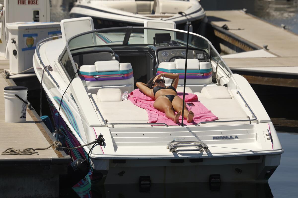 Blanca Herrera, of Compton, CA, sunbaths on a boat in San Pedro, as temperatures soar on Monday.