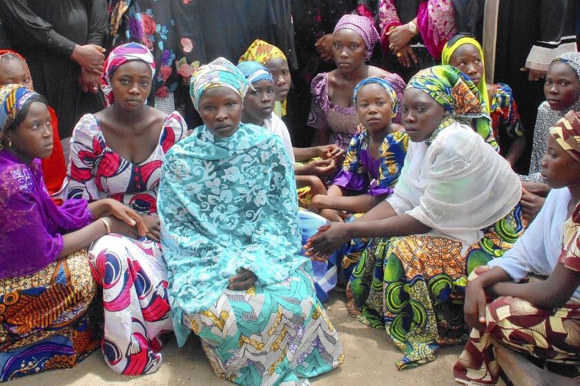 Schoolgirls who escaped from Boko Haram militants receive information from Nigerian officials.
