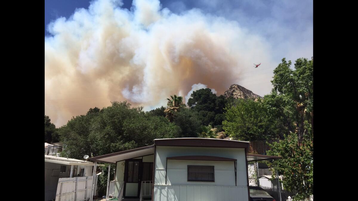 The Crescent Valley mobile home park is evacuated as a brush fire burns in the hills above Santa Clarita.