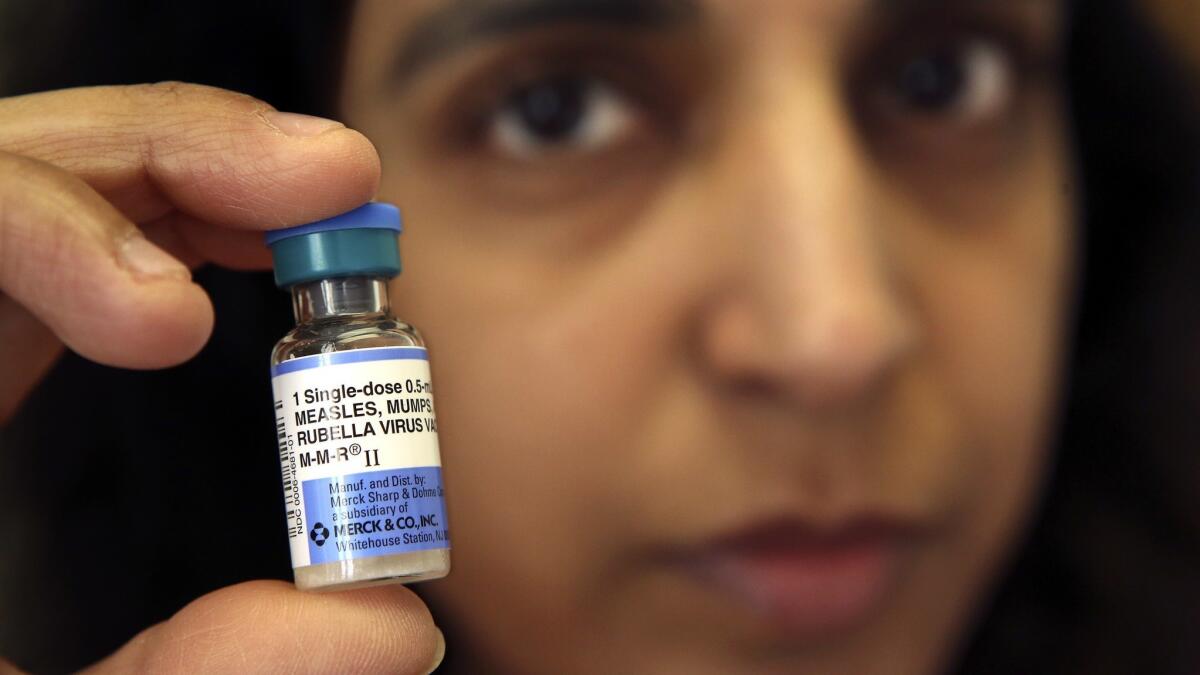 Dr. Monica Asnani holds a vial containing the measles vaccine at her office on Wilshire Boulevard.