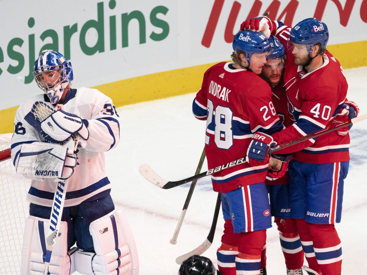 Montreal Canadiens' Christian Dvorak (28) celebrates with teammates Jonathan Drouin (92) and Joel Armia (40) after scoring the second goal against Toronto Maple Leafs goaltender Jack Campbell (36) during first-period preseason NHL hockey game action in Montreal, Monday, Sept. 27, 2021. (Ryan Remiorz/The Canadian Press via AP)