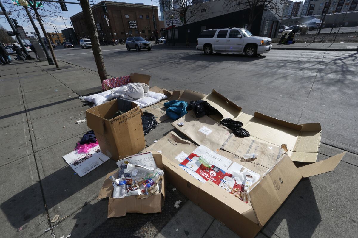 Traffic passes by the belongings of a homeless person evicted from a camp near the Samaritan House in Denver.