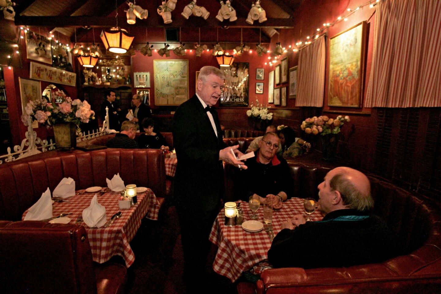 Now-retired waiter Vladimir Bezak interacts with customers at Dan Tana's restaurant in West Hollywood in 2009.