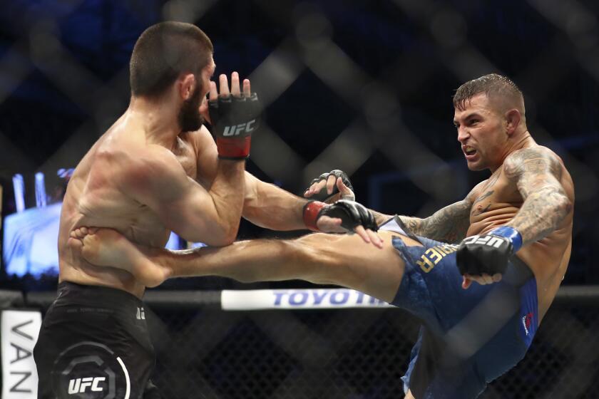 Russian UFC fighter Khabib Nurmagomedov, left, fights with UFC fighter Dustin Poirier, of Lafayette, La., during Lightweight title mixed martial arts bout at UFC 242, in Yas Mall in Abu Dhabi, United Arab Emirates, Saturday , Sept.7 2019. (AP Photo/ Mahmoud Khaled)