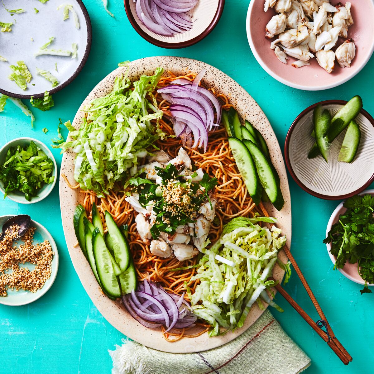 Chilled Sichuan noodles maintain all their chile warmth, without the chile sting, when made at home with chile crisp and sesame paste in the dressing and loads of crunchy vegetables and creamy crab on top. Prop styling by Nidia Cueva.