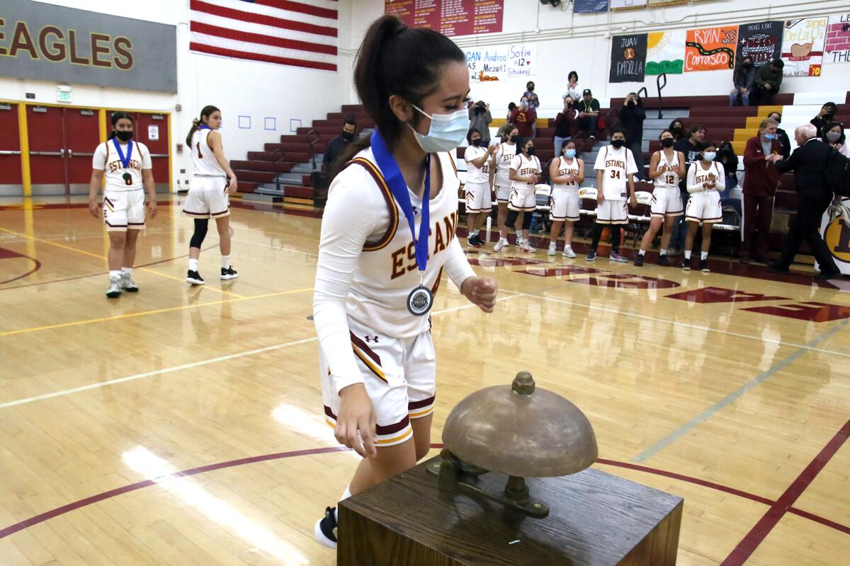 Estancia's Alexis Orellana (4) rings the "Bell Trophy" after winning the rivalry game against Costa Mesa on Tuesday.