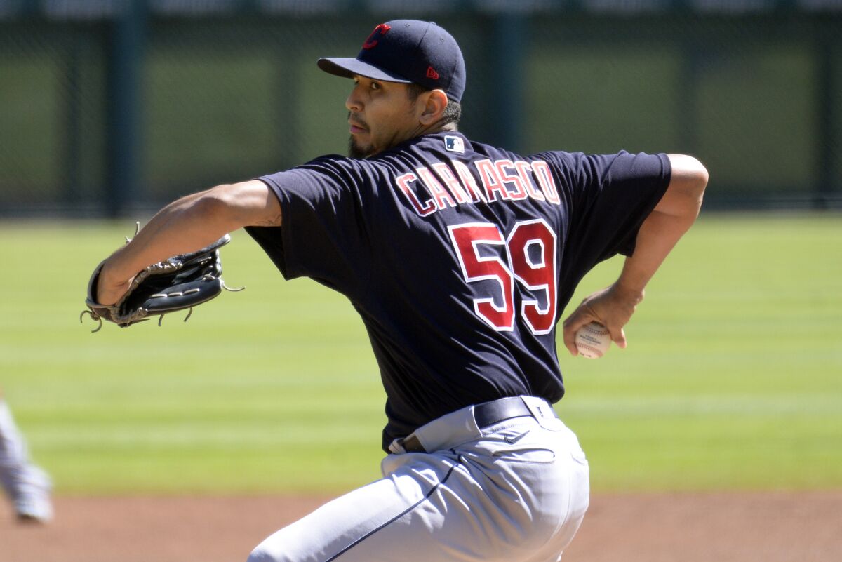 On the mound, Cleveland Indians starter Carlos Carrasco winds up for a pitch.
