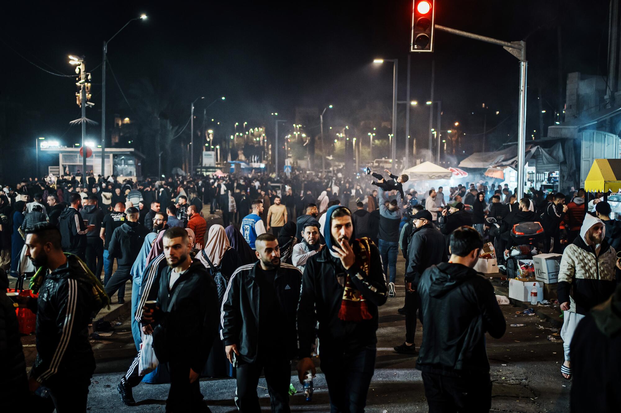 夜间，人群在大马士革门附近的耶路撒冷老城外四处走动。
