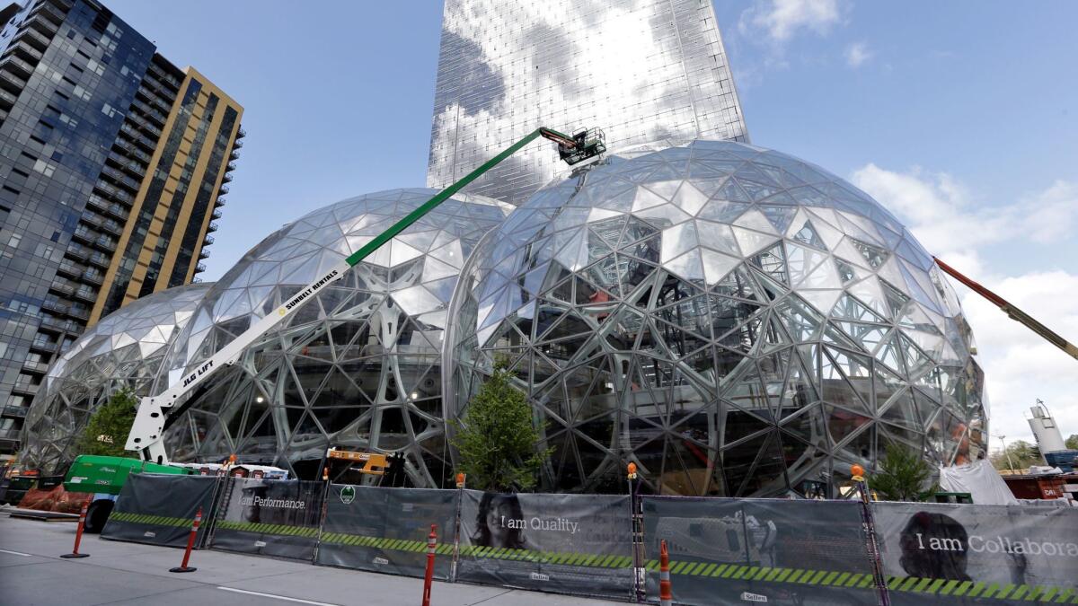Three large glass domes mark where Amazon is expanding its Seattle headquarters; now it wants to build a second HQ in a city to be named later. How much will be bid?