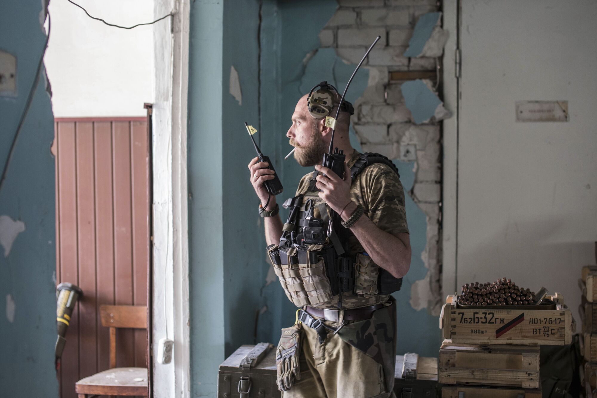 A Ukrainian soldier holds radios in a doorway