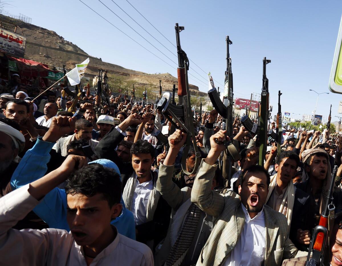 Houthi supporters rally in the Yemeni capital, Saana, some with rifles pointed in the air.
