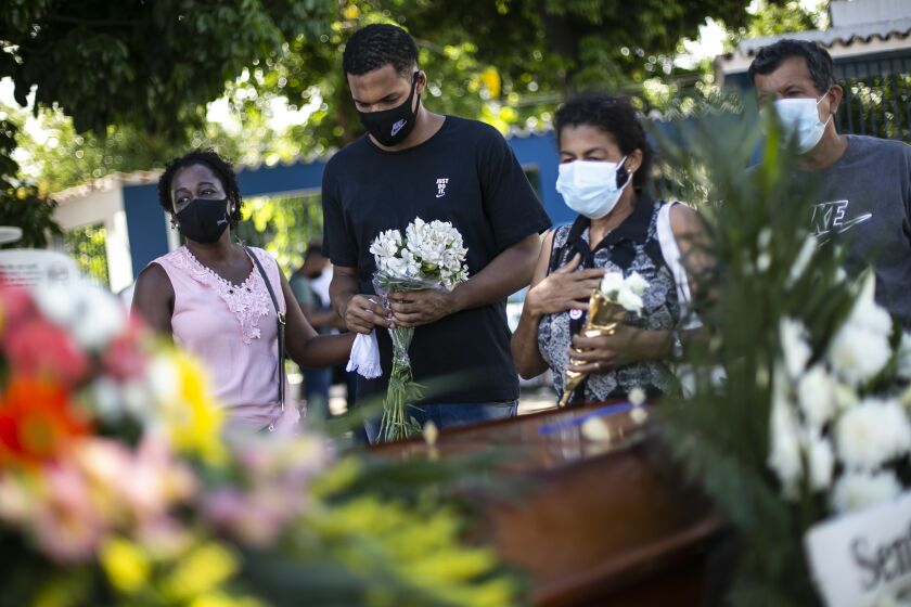 Relatives attend the burial of 71-year-old Jose Abelardo Bezerra, who died from COVID-19 related complications, at the Inhauma cemetery in Rio de Janeiro, Brazil, Thursday, Jan. 7, 2021. (AP Photo/Bruna Prado)