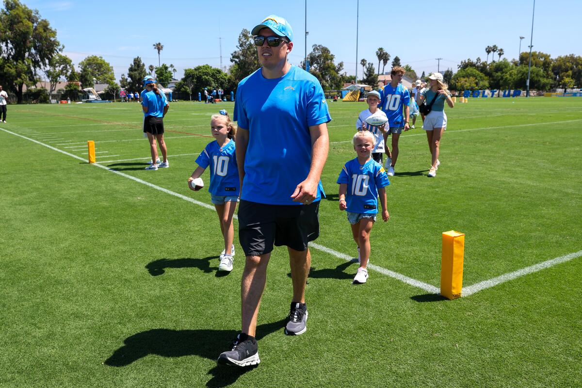 Chargers offensive coordinator Kellen Moore leads his family across the practice field.