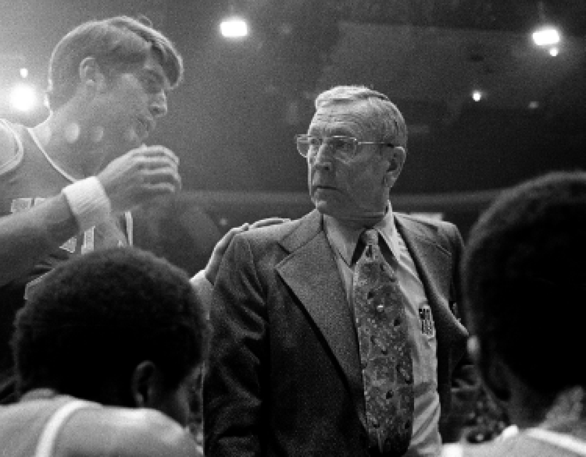 UCLA basketball coach John Wooden listens to Greg Lee, left, during a break against Iowa Jan. 28.  17, 1974, in Chicago.
