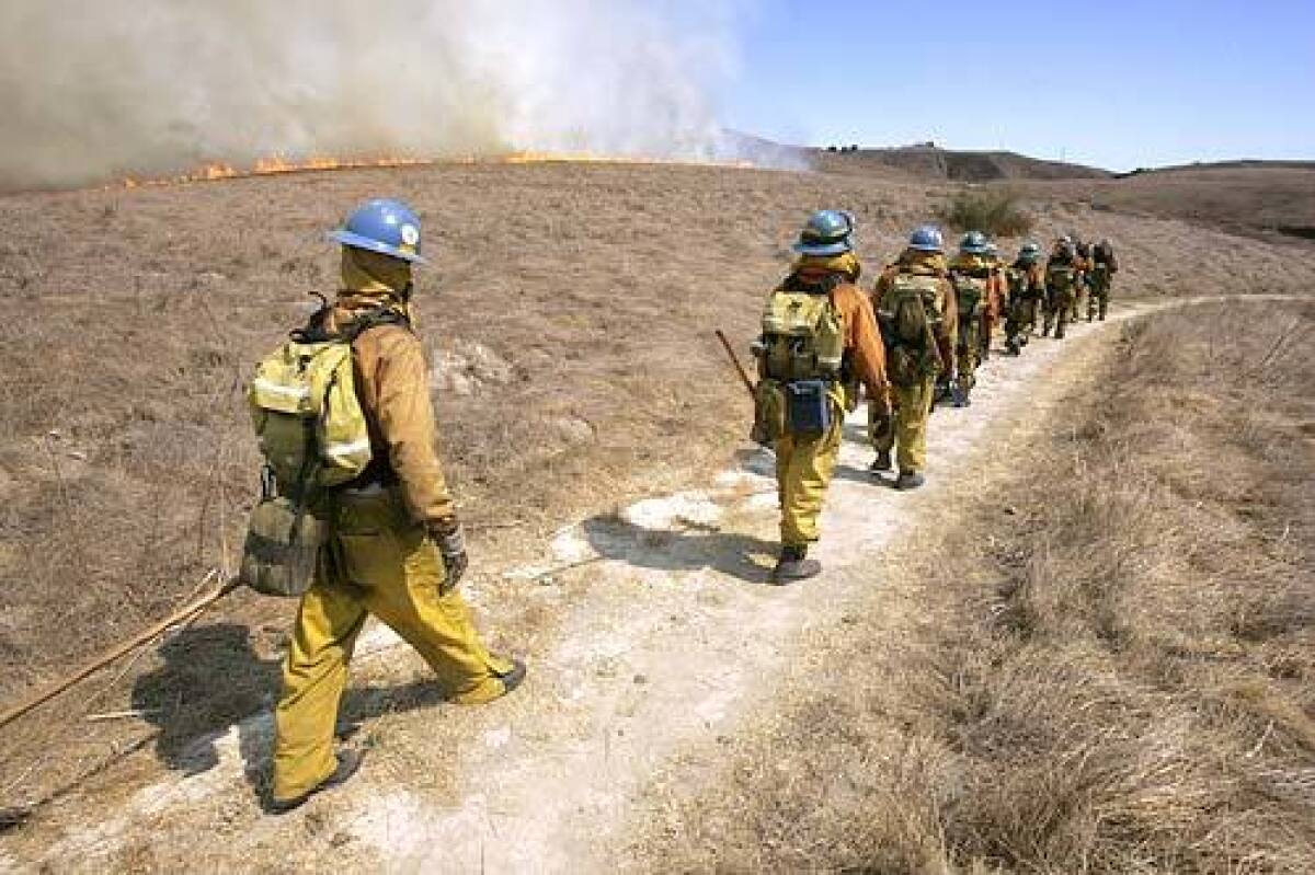 Los bomberos del condado de Los Ángeles luchan contra un incendio cerca de Chesebro Canyon.