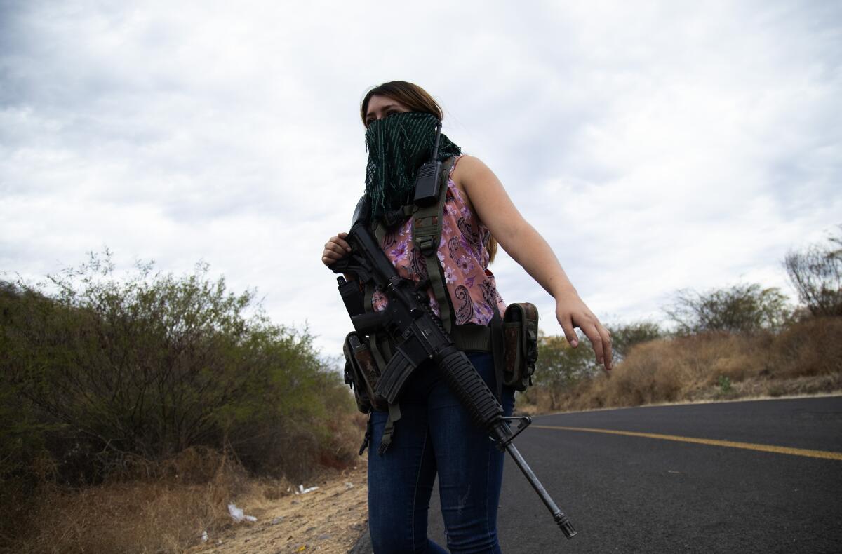 Una mujer armada vigila las afueras de El Terrero, en el estado de Michoacán, México, el jueves 14 de enero de 2021. 