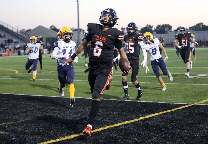 Huntington Beach quarterback AJ Perez (6) steps into the end zone for a touchdown.