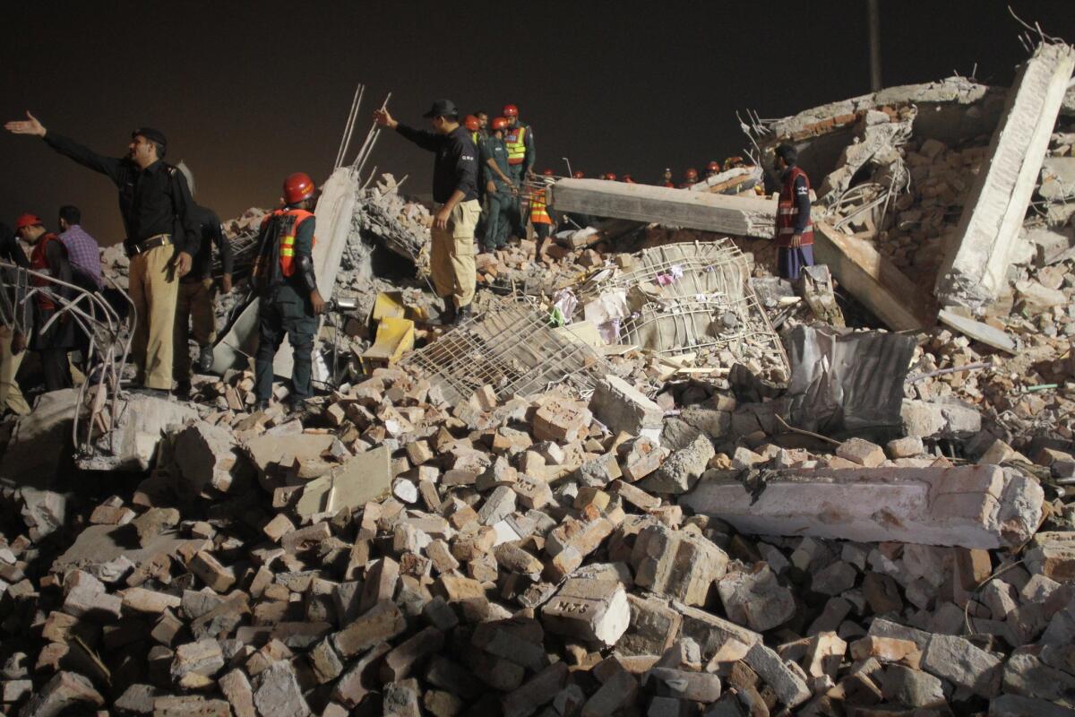 Voluntarios y agentes policiales pakistaníes toman parte en el rescate tras el derrumbe de un edificio en Lahore, Pakistán. Por lo menos 26 personas murieron y 103 resultaron lesionadas en el derrumbe de Lahore.