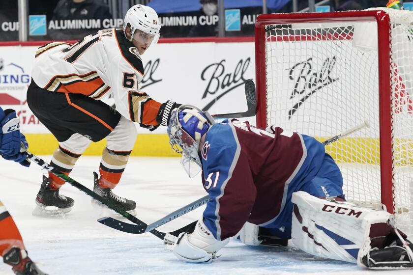 Anaheim Ducks center Troy Terry, left, scores a goal on a snipe past Colorado Avalanche goaltender Philipp Grubauer in the third period of an NHL hockey game Monday, March 29, 2021, in Denver. (AP Photo/David Zalubowski)