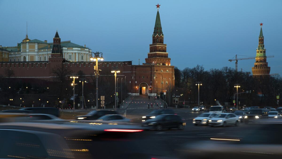 Cars pass the Kremlin in Moscow on Monday.