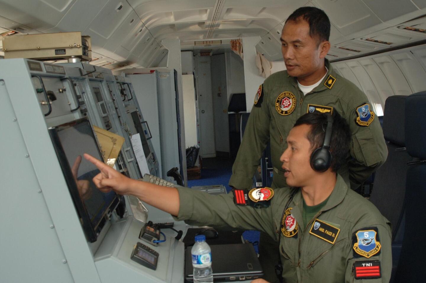 Indonesian Air Force personnel aboard an Indonesian Air Force military surveillance aircraft over the Malacca Strait, a sea passageway between Indonesia and Malaysia, while searching for the missing Malaysia Airlines flight MH370 plane.