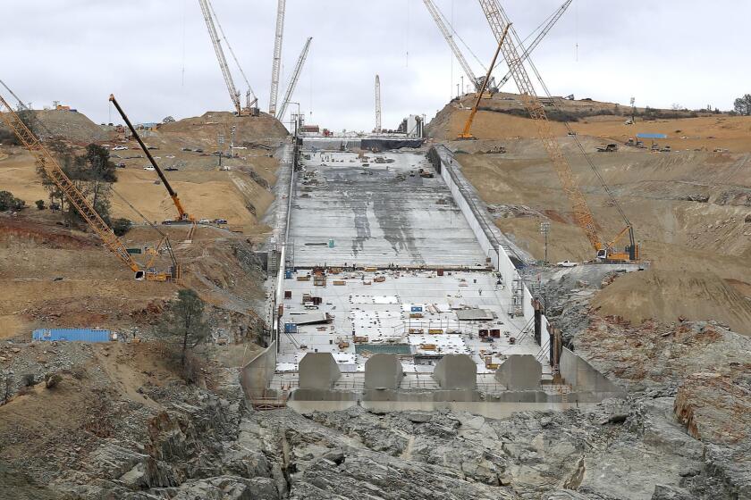 OROVILLE, CALIF. - OCT. 19, 2017. Construction crews repair the main spillway of the Oroville Dam in Oroville on Thursday, Oct. 19, 2017. Heavy rains caused failures of the main and emergency spillways last February, leading to the evacuation of 188,000 people living near the dam. Excessive water flow created a huge crater at about the midpoint of the main spillway, and crews now are trying to finish repair work ahead of the coming winter. (Luis Sinco/Los Angeles Times)