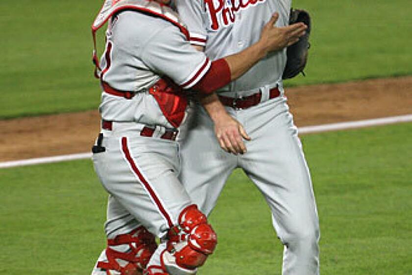 Phillies catcher Carlos Ruiz, who had a three-run home run in the fifth inning, and closer Brad Lidge congratulate each other after an 8-6 victory over the Dodgers in Game 1 of the National League Championship Series on Thursday night at Dodger Stadium.