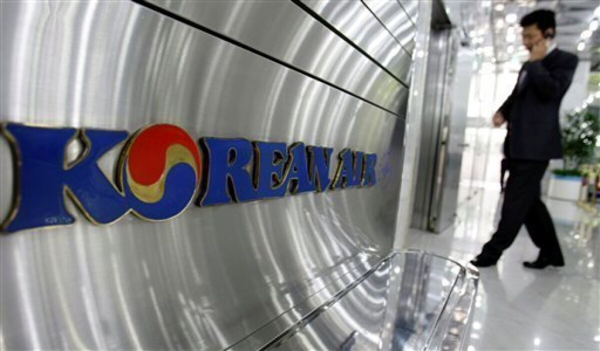 A South Korean man uses his mobile phone at a showroom of the headquarters of Korean Air Co. in Seoul, South Korea, Thursday, May 7, 2009. Korean Air Lines Co. said Thursday its first quarter net loss widened as weakness in the South Korean won drove up costs denominated in dollars. (AP Photo/ Lee Jin-man)