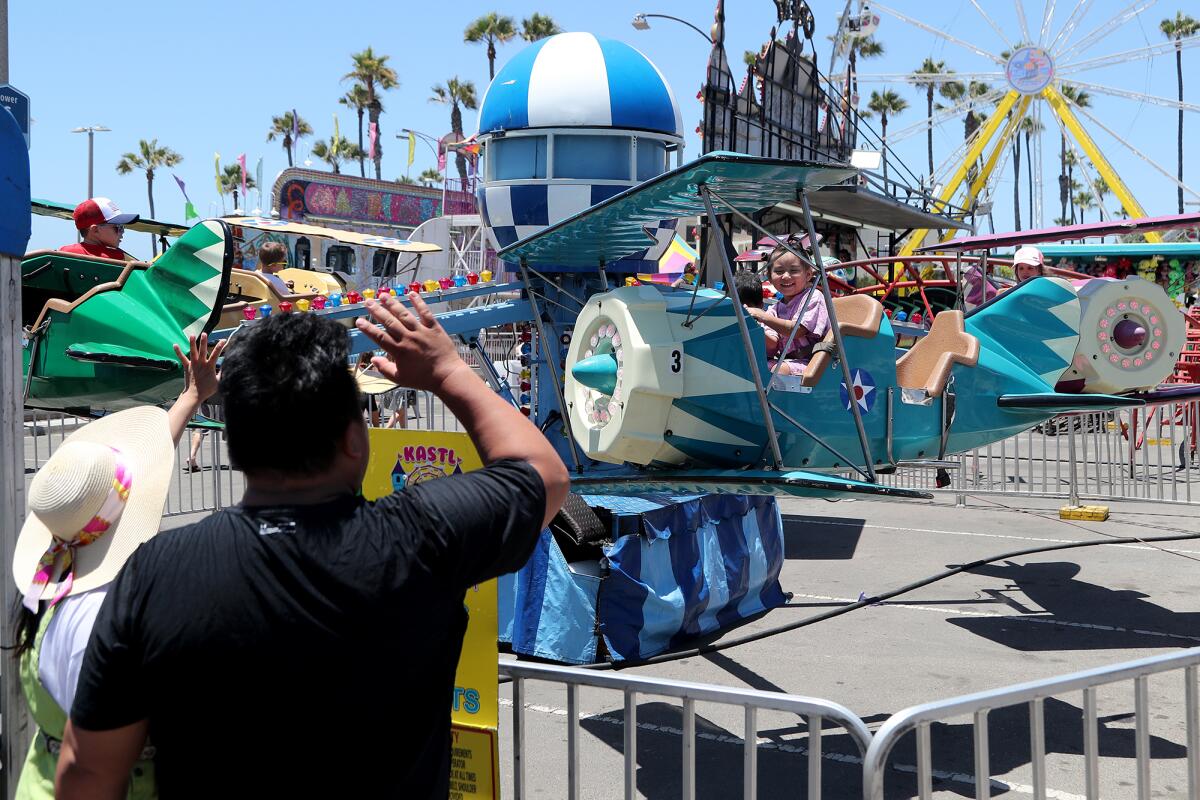 Parents wave to their children as they enjoy themselves aboard the Kastl Amusements Spider Mania ride.