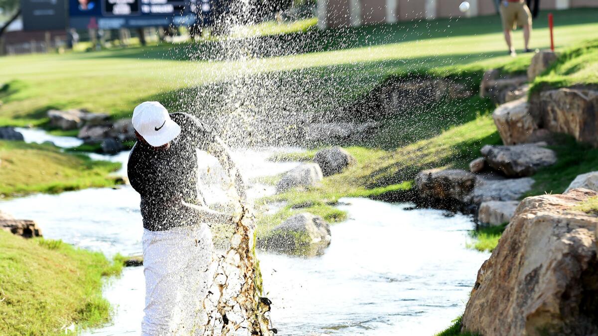 Tony Finau plays his fourth shot out of a creek along the 18th hole during the second round of the Texas Open on Friday.