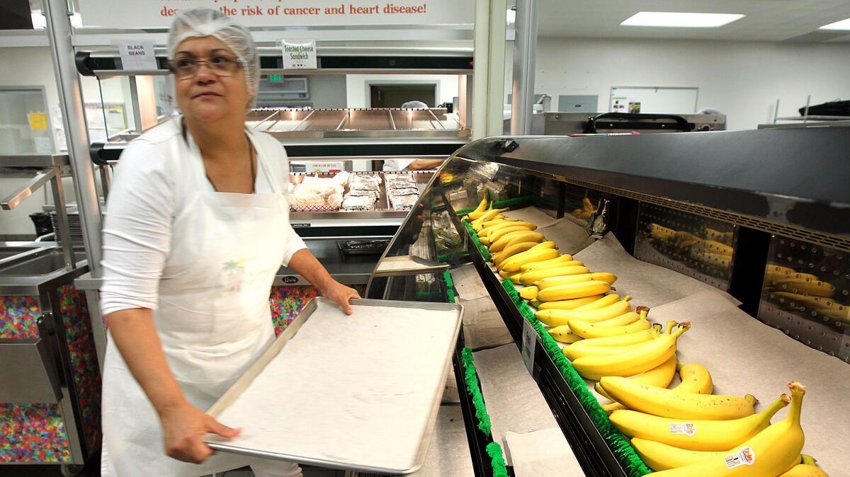 L.A. Unified has followed federal guidelines in offering more fruit and also making students put more fruit and vegetables on their trays, as overseen by kitchen worker Linda Gomez at Bravo Medical Magnet High School in 2014.