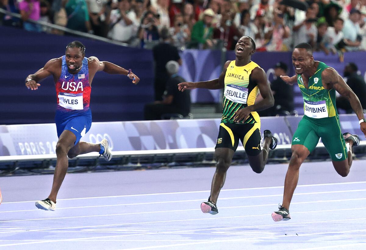 PARIS, FRANCE August 3, 2024-USA's Noah Lyles, left, crosses the finish line to win.