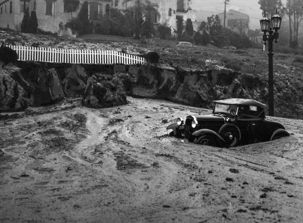 March 2, 1938: Mudslide at Harper Avenue and Sunset Boulevard caught this automobile and closed the area to traffic.