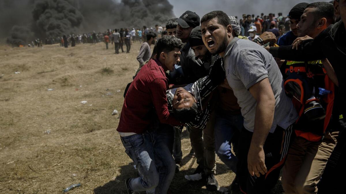Palestinians carry an injured man during clashes with Israeli forces near the border between the Gaza Strip and Israel on Monday.