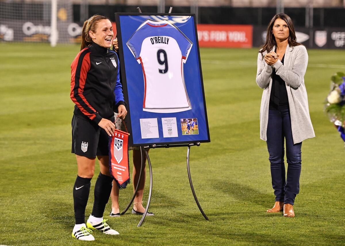 United States' Heather O'Reilly (9) is joined on the field by former player Mia Hamm as O'Reilly is honored before her final international match, against Thailand on Sept. 15.